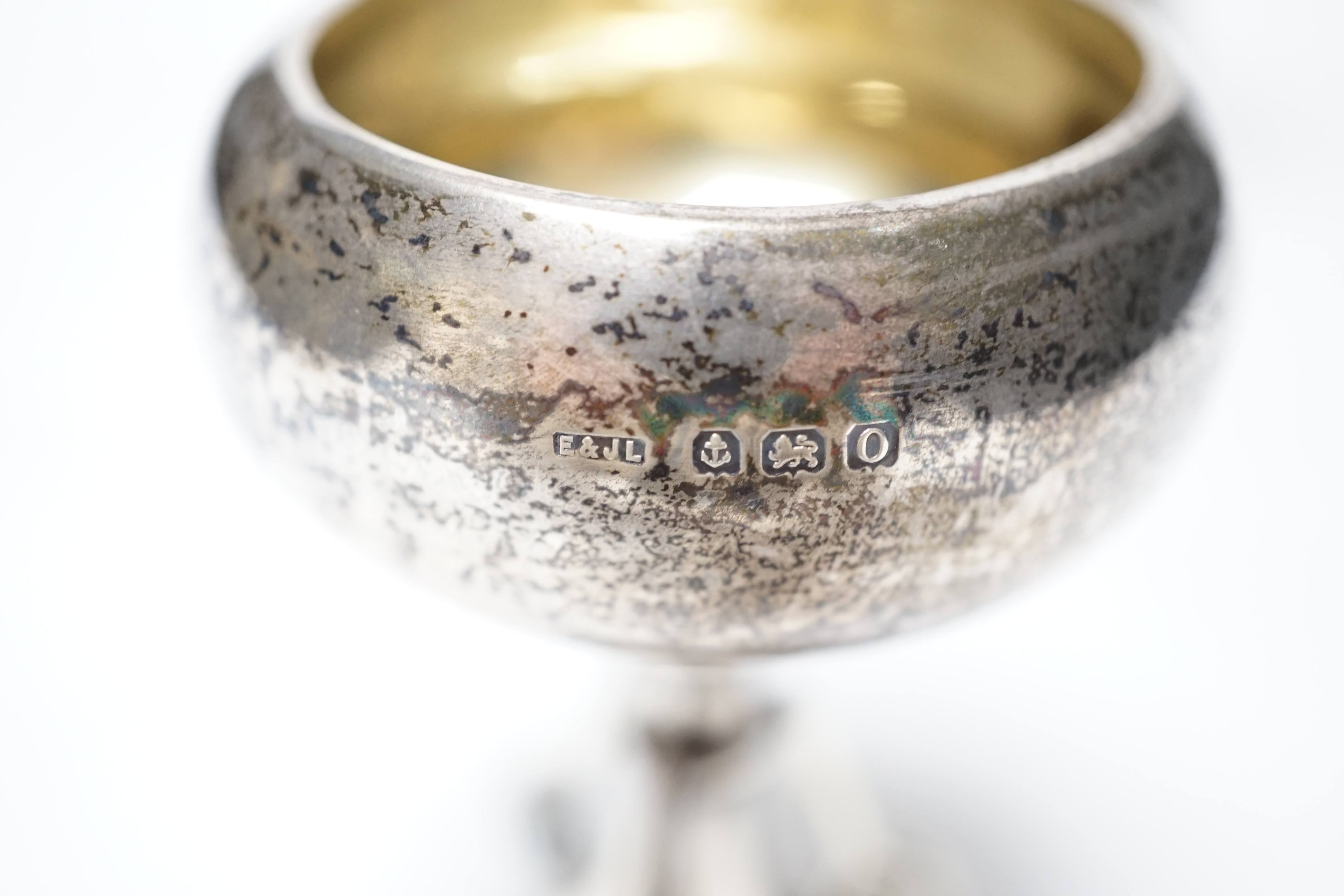 A set of three small George V silver tennis related trophy cups, with racket supports and engraved inscriptions, E & J Leek, 92mm, two with plinth bases.